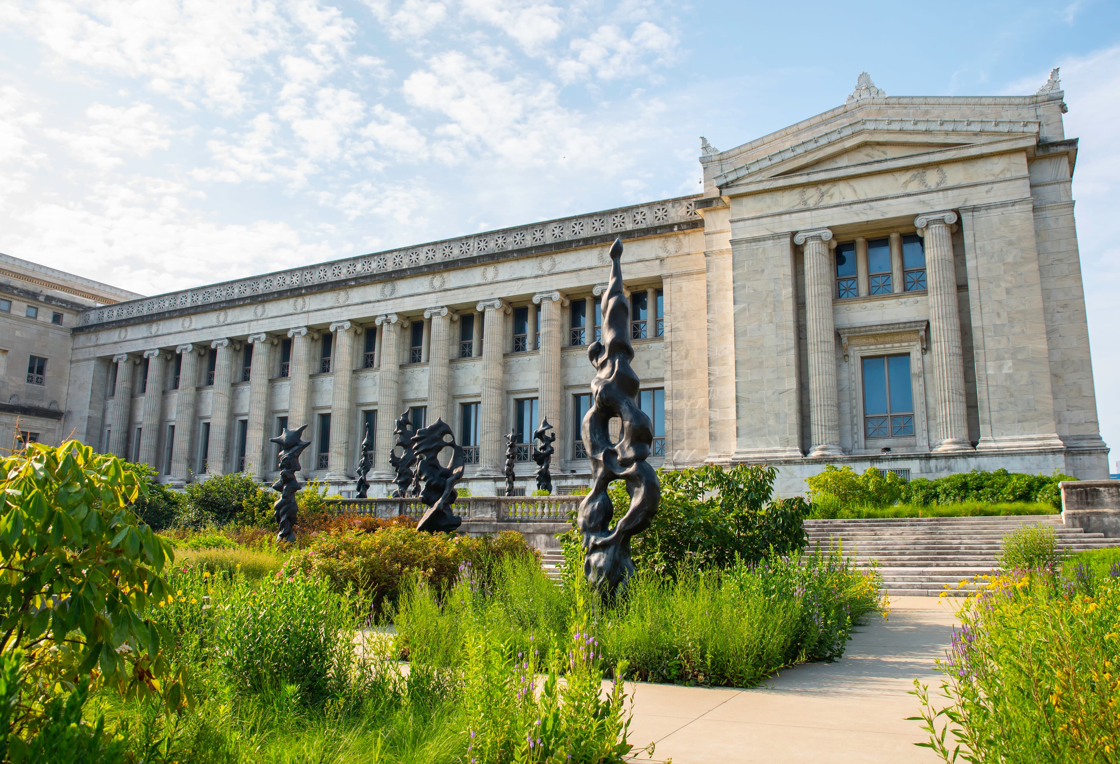 Native plant gardens with black sculptural totems, outside the museum building.