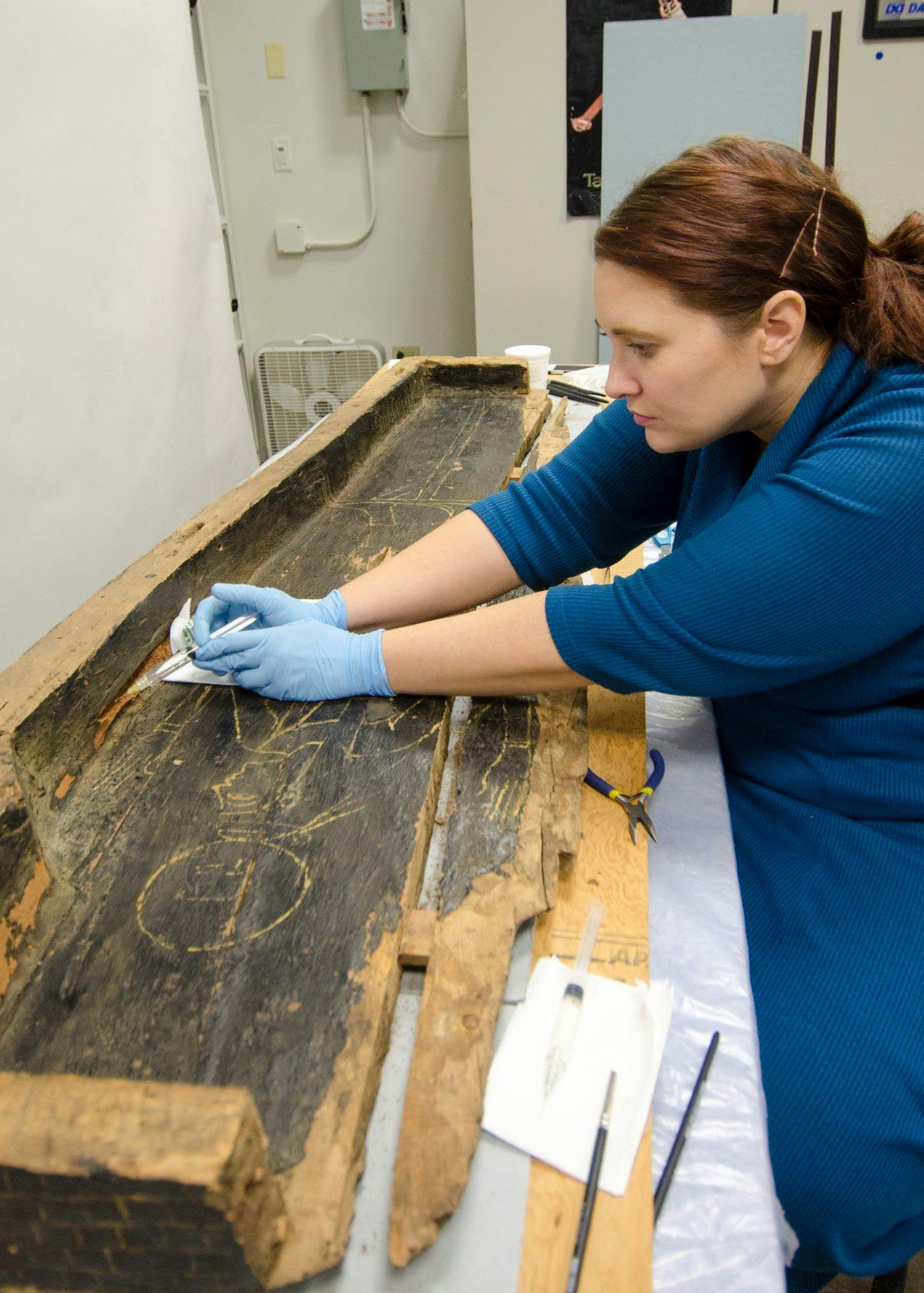 Conservator works on an Egyptian coffin.