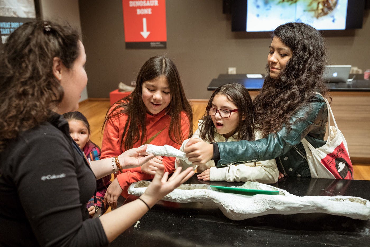 Young visitors and a museum educator examine a teaching specimen together in the Grainger Science Hub