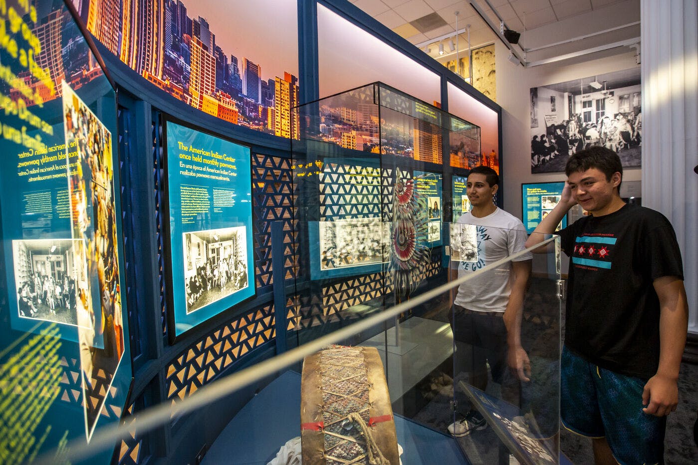 Two visitors view exhibit cases and mulitimedia in an exhibition