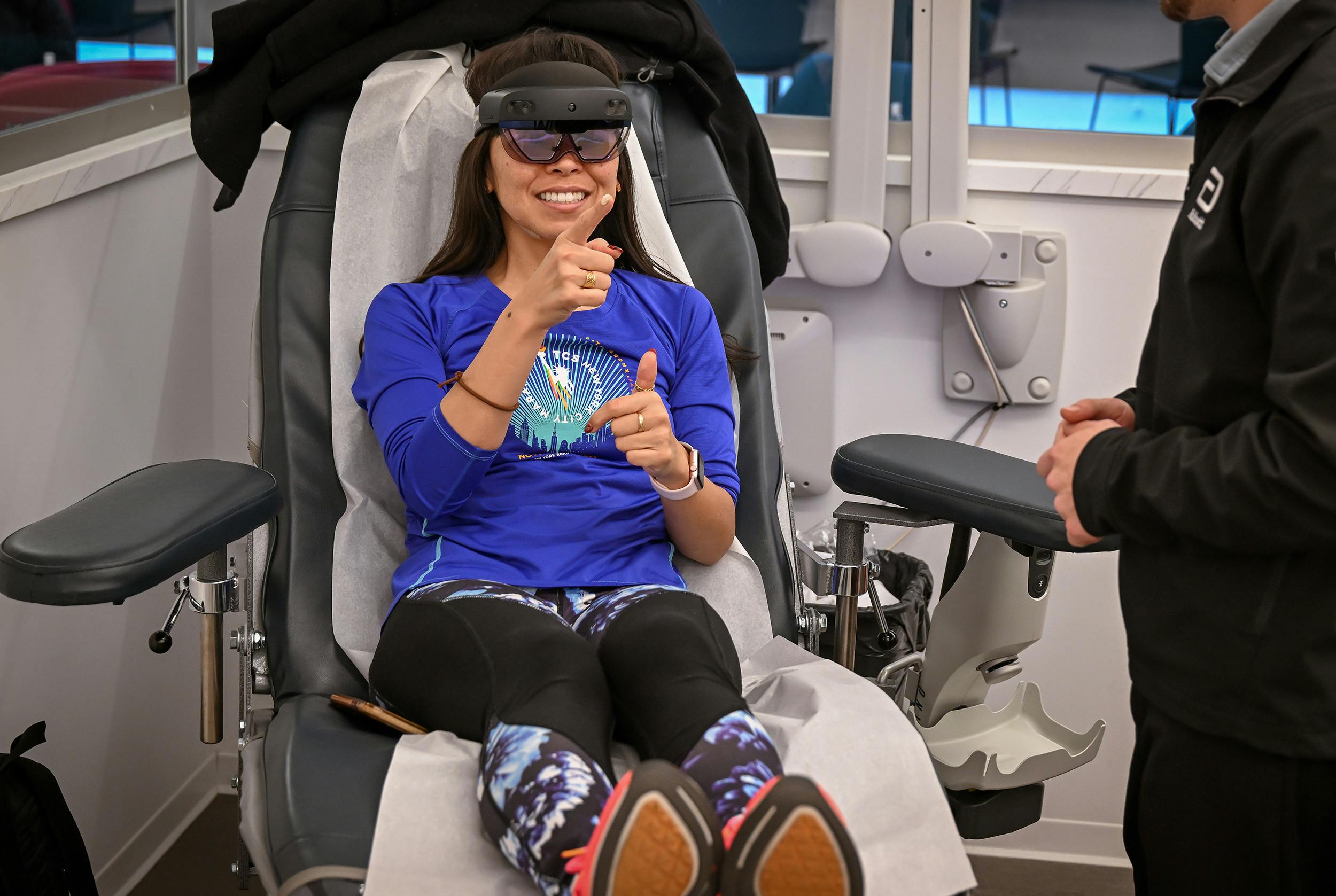 A woman preparing to donate blood while wearing the mixed-reality headset.